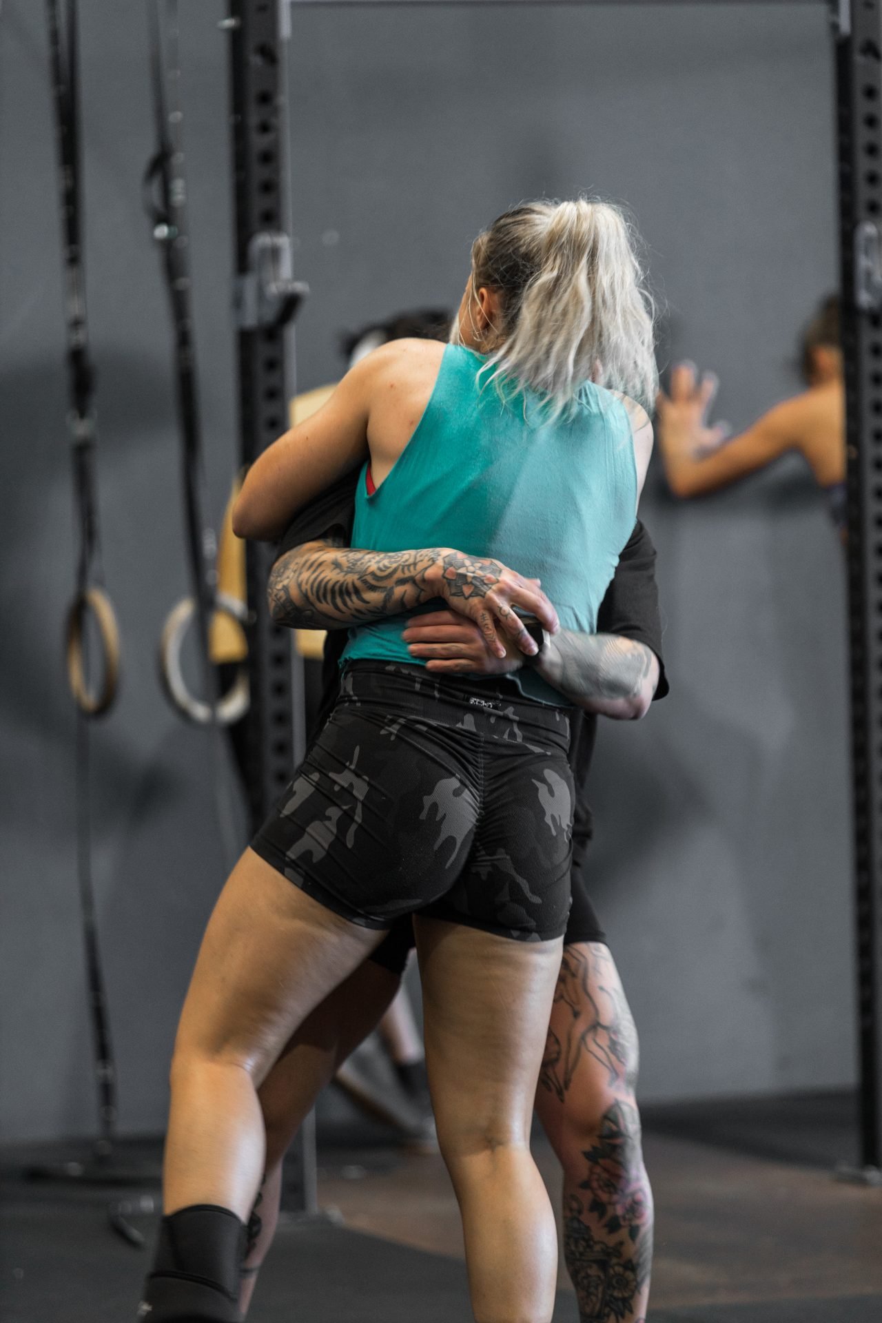A woman hugging her gym buddy smiling on each other